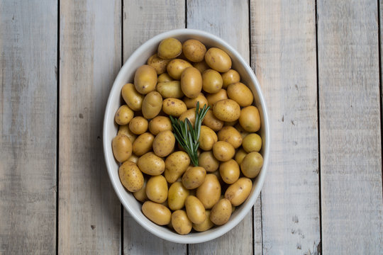 Raw baby potatoes in pan with rosemary, ready to cook in oven