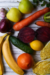 A set of products for detox diet. Fresh fruits and vegetables on a white wooden background. Ration for weight loss from a nutritionist. Vegetarian food without meat.
