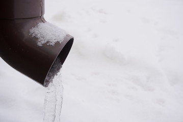 Icicles hanging over a frozen water tube at roof.