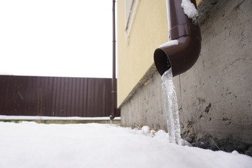 Icicles hanging over a frozen water tube at roof.