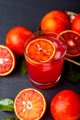 Red cocktail from bloody red oranges on dark background