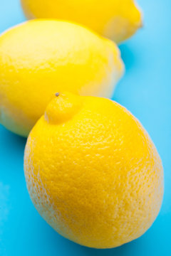 Three exotic yellow lemon on a blue background.