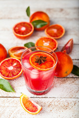 Red cocktail from bloody red oranges on wooden background