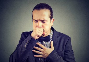 Man coughing heavily on gray
