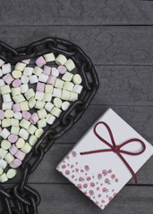 sweet heart shape of marshmallows with metal chain on wood background, decoration for love and valentine day concept.