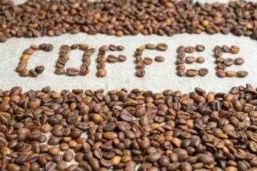 Spilled grains of fragrant coffee close-up.
