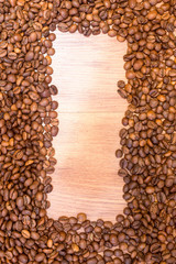 Spilled grains of fragrant coffee close-up. Photo frame, background.