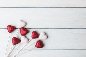 Naklejka na ściany i meble Red and white hearts over wooden background