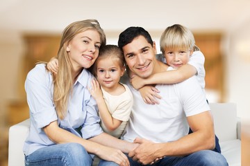 Obraz premium Beautiful smiling family sitting at sofa