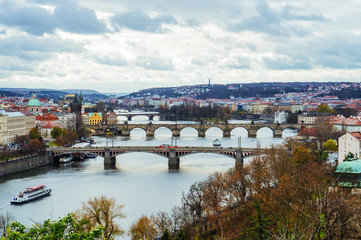 Fototapeta na wymiar Scenic view of bridges on the Vltava river and of the historical center of Prague: buildings and landmarks of old town with red rooftops. Concept of Europe travel, sightseeing and tourism.