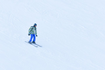 Fototapeta na wymiar BUKOVEL, UKRAINE- 27 JANUARY 2018: Man skiing down the snow-covered slope