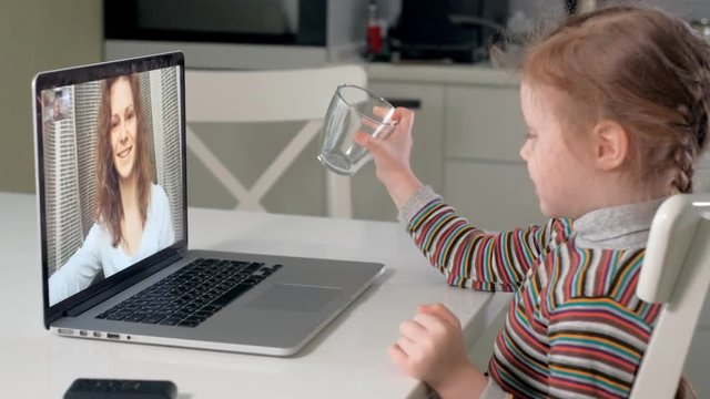 little girl talking to mom using laptop