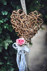 Wicker heart with pink rose. Decoration for Valentine's day, Mother's day, wedding or any formal occasion.