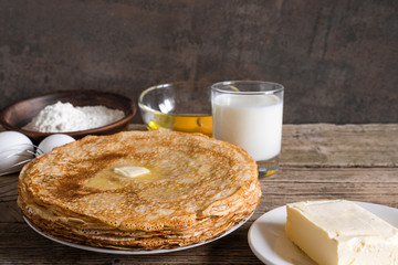 stack of pancakes with butter and ingredients for breakfast.