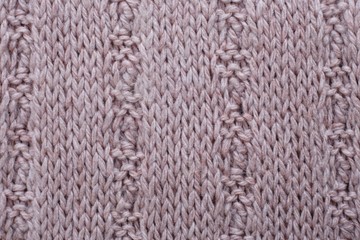 Knitted texture of beige woolen fabric with pattern. Copyspace, background