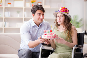 Young family celebrating birthday with disabled person