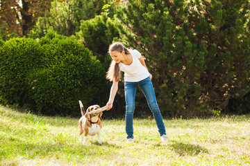 Naklejka na ściany i meble Girl plays with a dog in the yard
