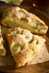 Homemade rhubarb scones on wooden plate, photographed with natural light (Selective Focus, Focus one third into the image)