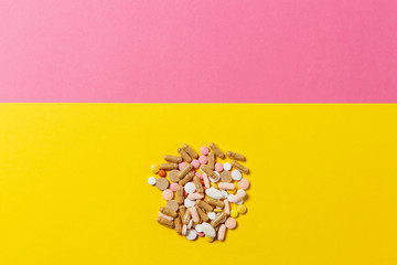 Medication white colorful round tablets arranged abstract on yellow pink color background. Aspirin...