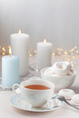 Romantic tea and white meringues with candles
