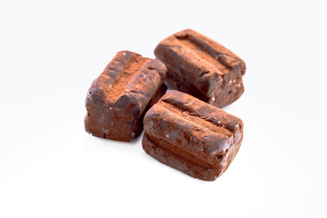 Italienische Trüffelpralinen - Tartufo dolce nero - auf weissem Hintergrund