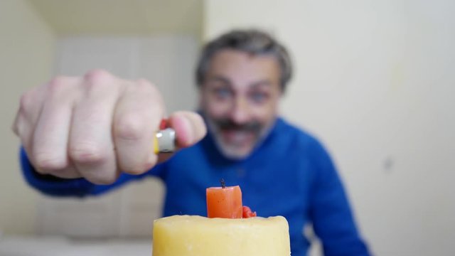 man lighting birthday candles