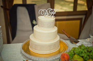 Three-tiered white-and-beige cake for the wedding 514.