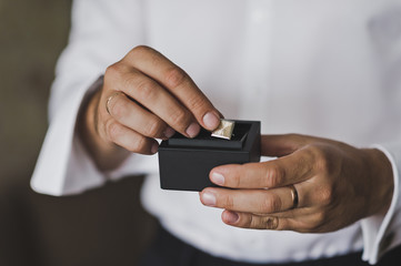 The man pulls out a box of cuff links 546.