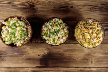 Set of festive mayonnaise salads on wooden table. Top view
