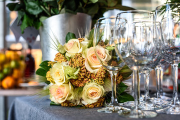 Beautiful flowers on the table with empty wine glasses