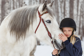 Little girl with a friesian horse, outdoor