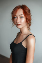 Fototapeta premium Redheaded girl in a black t-shirt in the Studio