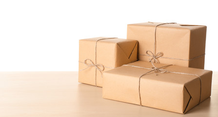 Parcel gift boxes on wooden table against white background