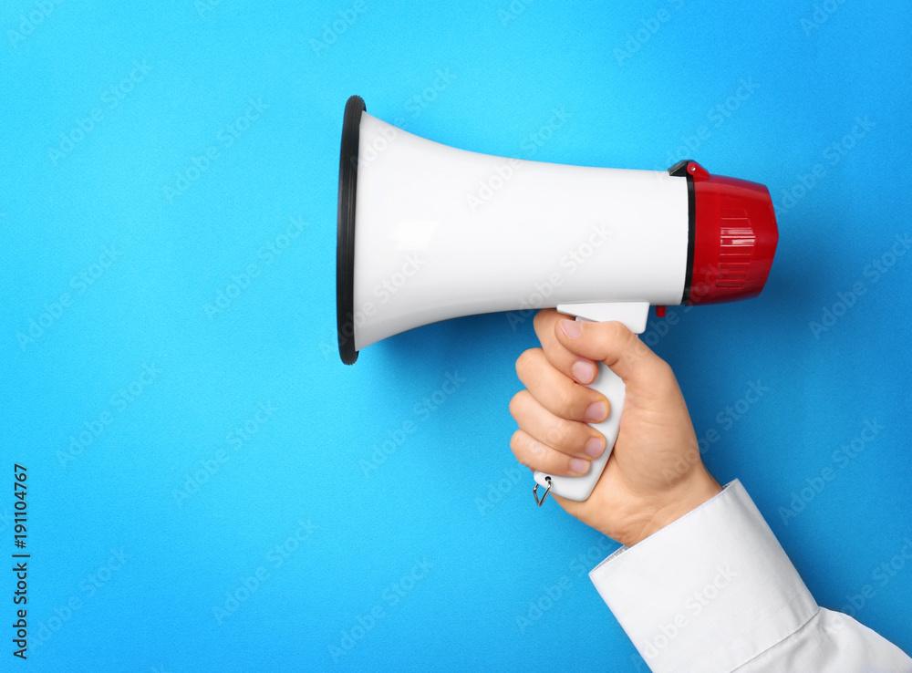 Wall mural man holding megaphone on color background