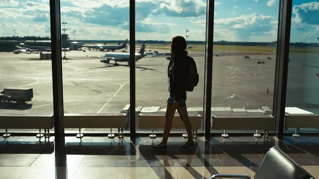 Woman tourist on the background of the airport runway