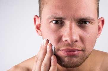 Obraz premium Close-up of young man applying shaving cream