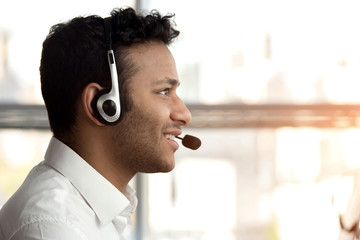 Side view stubbled black man with headset. Smiling black indian man with headset, close up.
