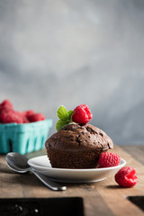 Chocolate muffins or cupcakes with raspberries, healthy breakfast, homemade snack, selective focus, toned image.
