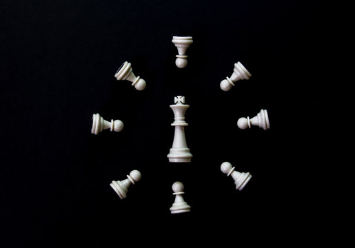 White chess clock on black background flat lay photo. White chess figures abstract ornament.