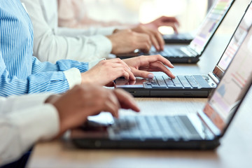 Female hands typing on laptop. Line of office workers hands typing on laptops computers.