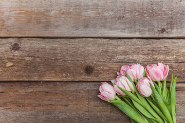 Bouquet of pink tulips over shabby wooden table. Spring greeting card happy mother day copy space