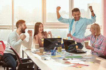 Group of winners celebrate victory or great success. Positive multi-ethnic team satisfied with...