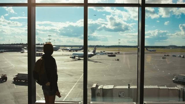 woman tourist looking at a plane flying away