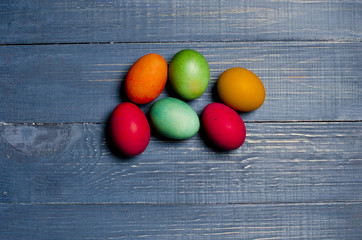 Painted chicken eggs for the traditional Christian holiday Easter on a wooden background painted blue.