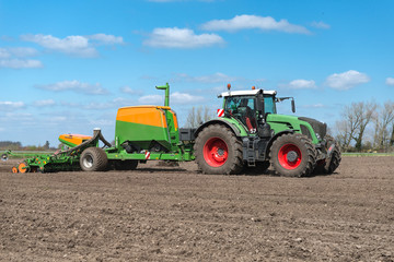Tractor with single grain sowing machine and fertilizer tank on the field - 9728