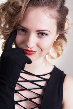 Pretty blond girl model like Marilyn Monroe in black dress with red lips on white background. 50's Vintage Fashion and Style. B&W. Portrait of rich young woman, material girl, femme fatale