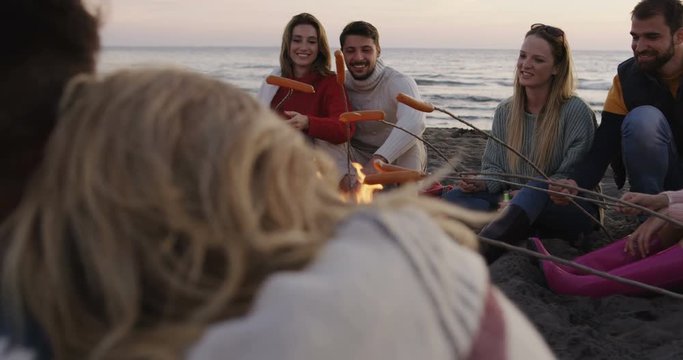 Friends Relaxing At Bonfire Beach Party. Shot on RED Helium 8K