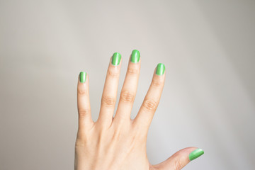 Woman hand with nails painted green