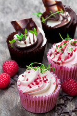 Chocolate  cupcakes with fresh raspberries and cream on wooden table