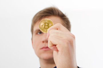 golden bitcoin coin with gold symbol in man hand isolated on white background. Businessman and success concept. Selective focus and copy space.
